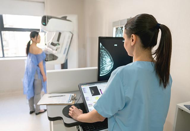 tech performs mammogram
