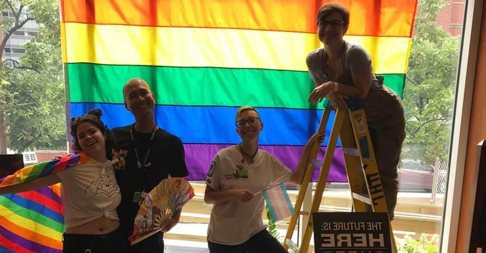 Hopkins students in front of pride flag