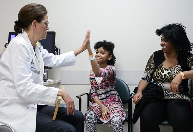 dr jaliyah gives a child a high five